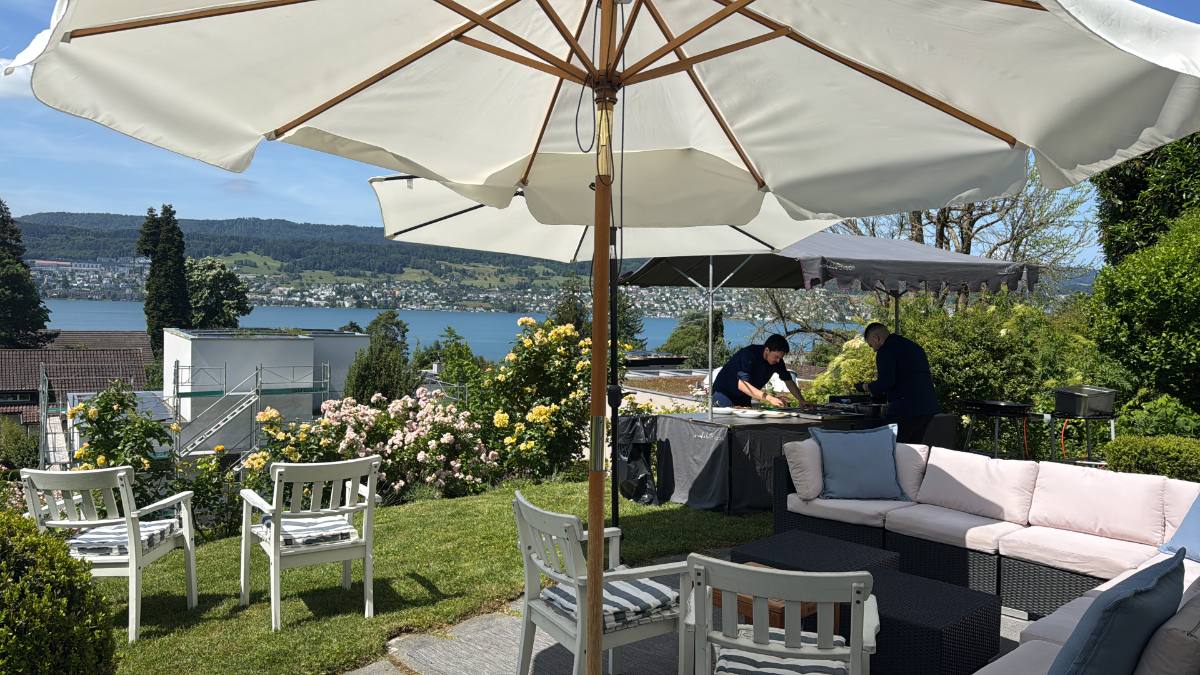 Eventlocation am See: Terrasse mit Sonnenschirmen und Lounge, Blick auf den See
