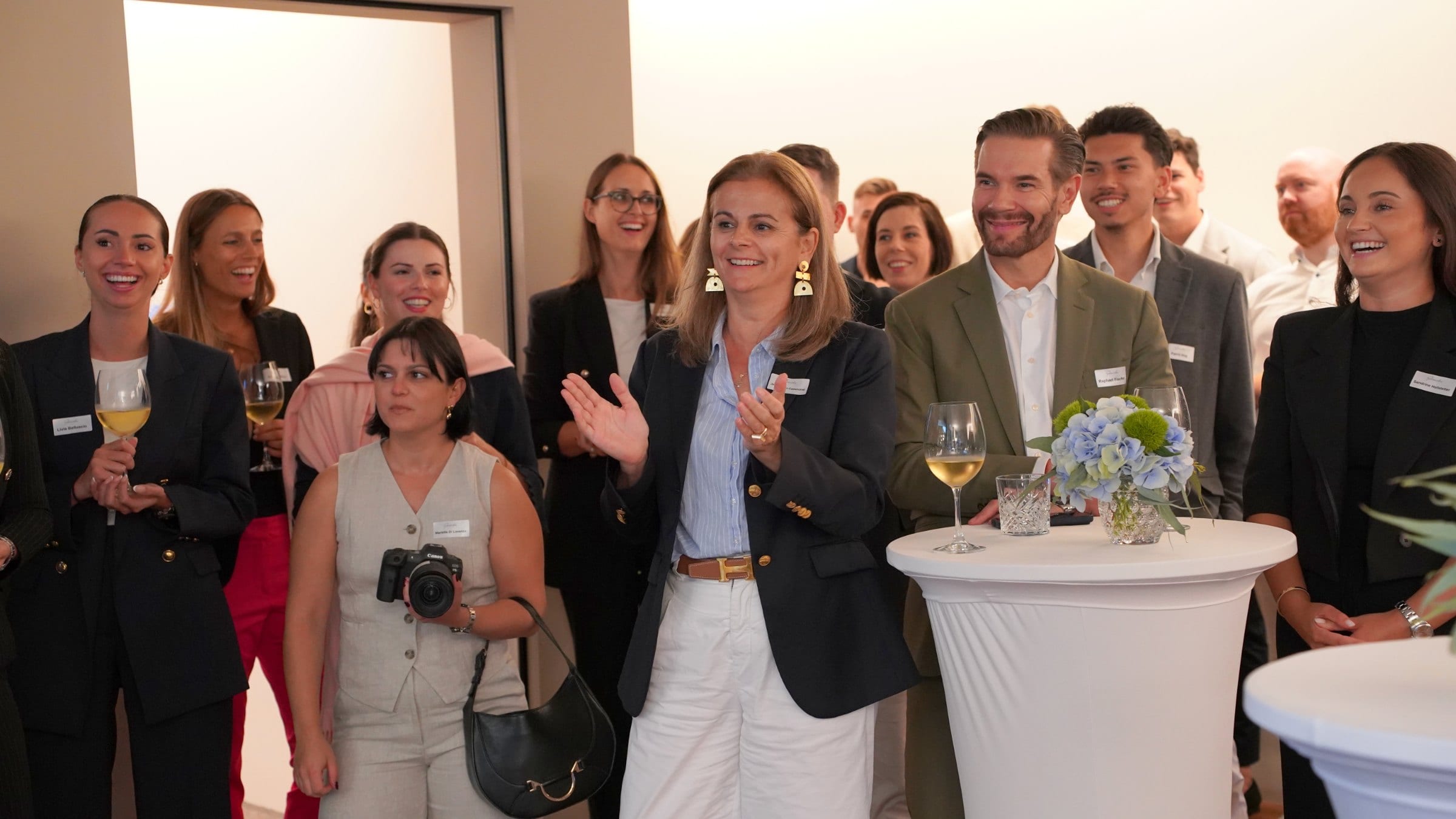 Gäste lachen an einer langen Tafel beim Firmenevent im Freien, Firmencatering Zürich