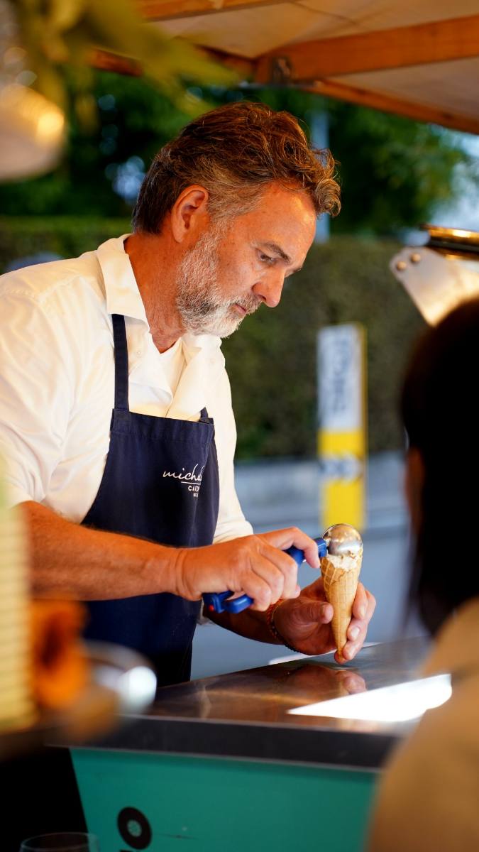 Michele scooping homemade ice cream into a cone: dessert station at a company event in Zürich