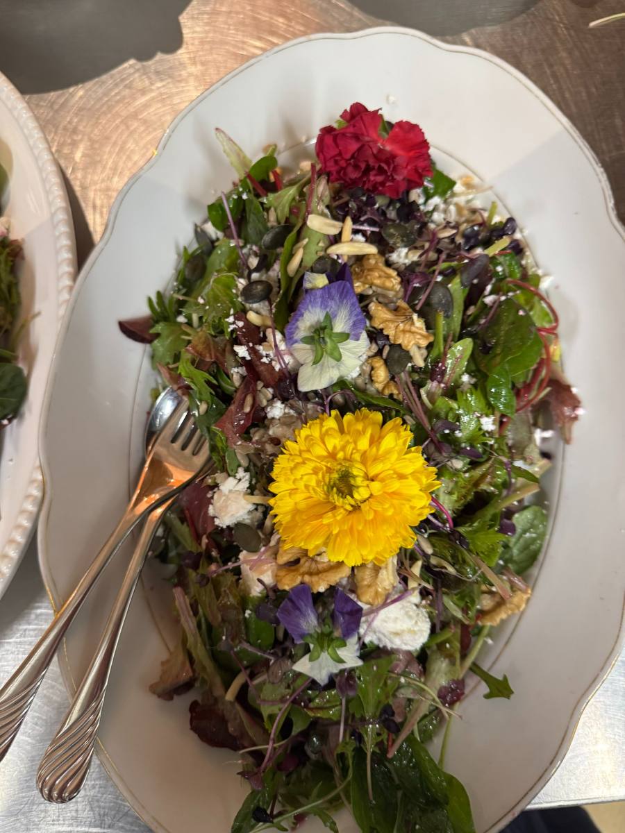 Mixed leaf salad with edible flowers, walnuts and seeds on a platter: wedding buffet with wedding catering from Zürich
