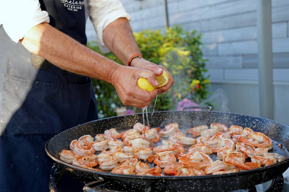 Live Cooking: Zitrone wird über Crevetten in der grossen Pfanne gepresst, Event-Catering Zürich