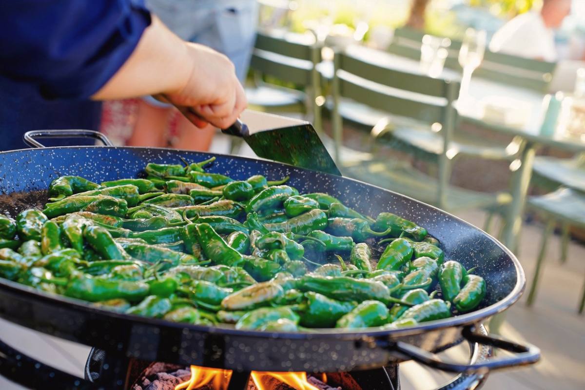 Live cooking: Padrón peppers in a large pan over an open fire, Zürich event catering