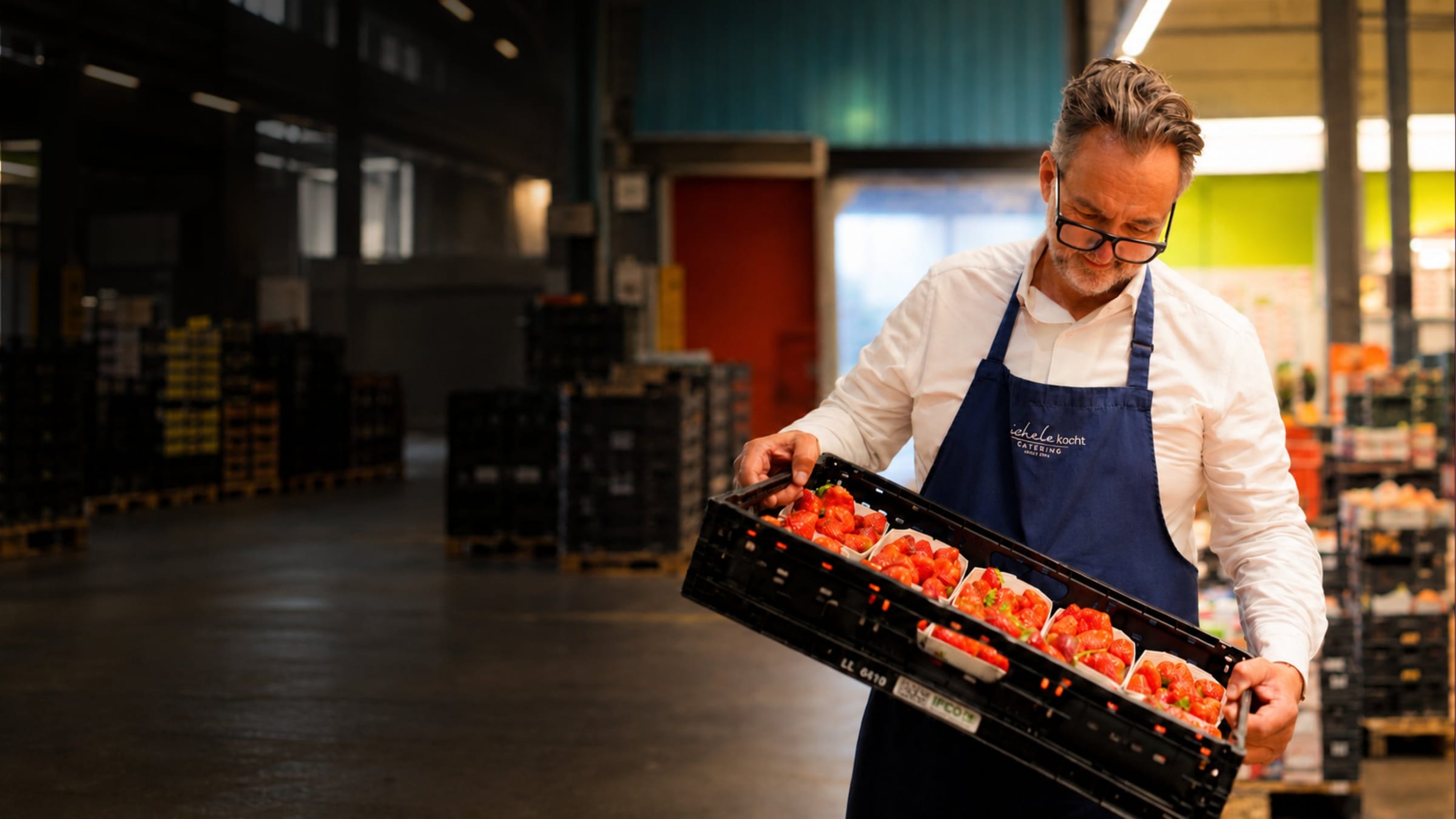 Michele trägt im ersten Morgenlicht eine Kiste Erdbeeren durch den Zürcher Engrosmarkt