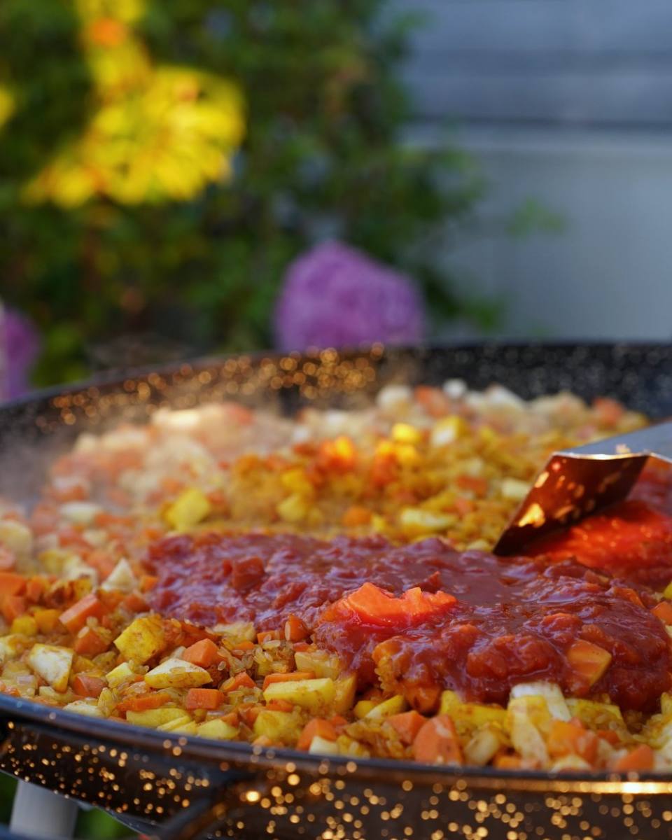 Steaming paella in the large pan: live cooking at an event in Zürich