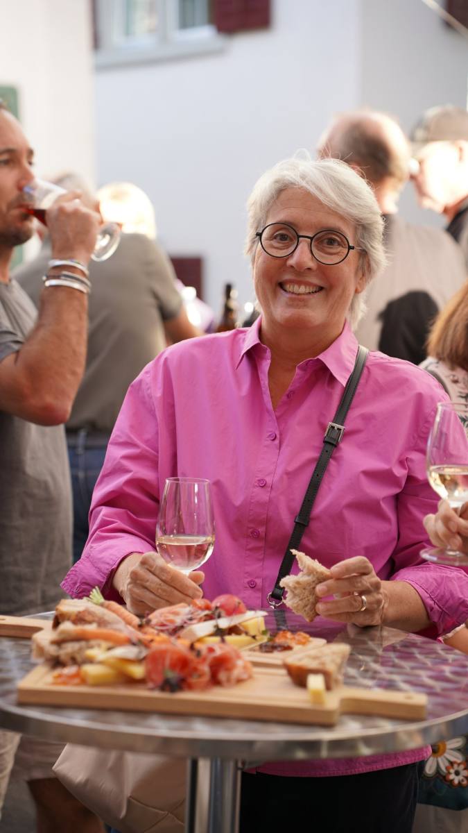 Guest with white wine and an apéro board at a standing table: apéro catering in Zürich