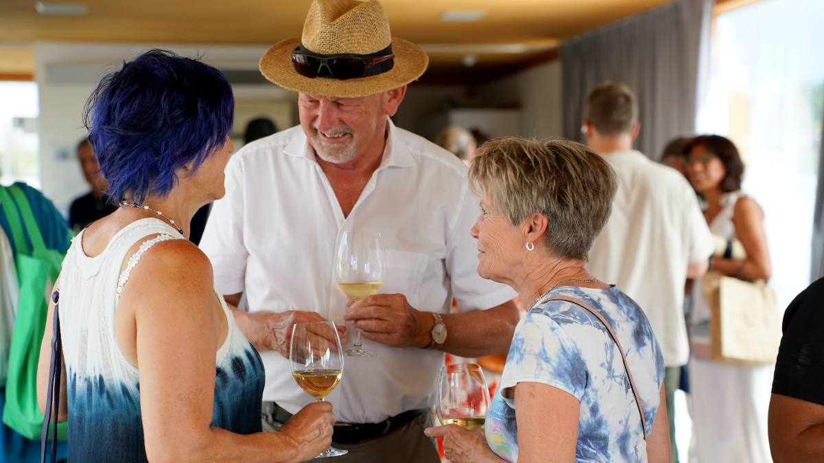 Gäste plaudern mit einem Glas Weisswein beim Apéro: privater Anlass mit Privatkoch in Zürich