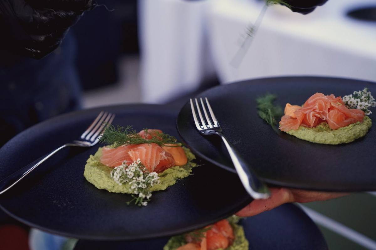 Serviertes Menü: Zwei angerichtete Gänge mit Lachs werden an den Tisch getragen, Catering Zürich