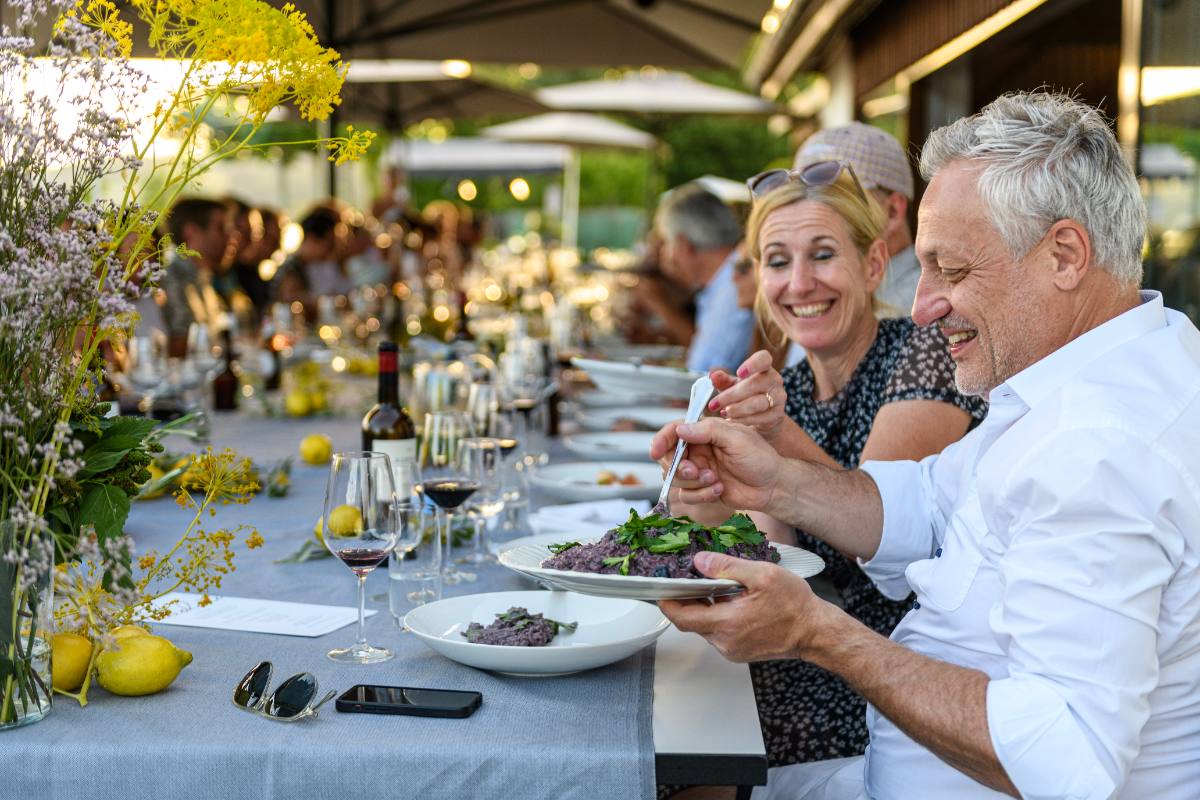 Gäste an der langen Tafel bei einem Sommerfest im Freien: private Feier mit Catering in Zürich