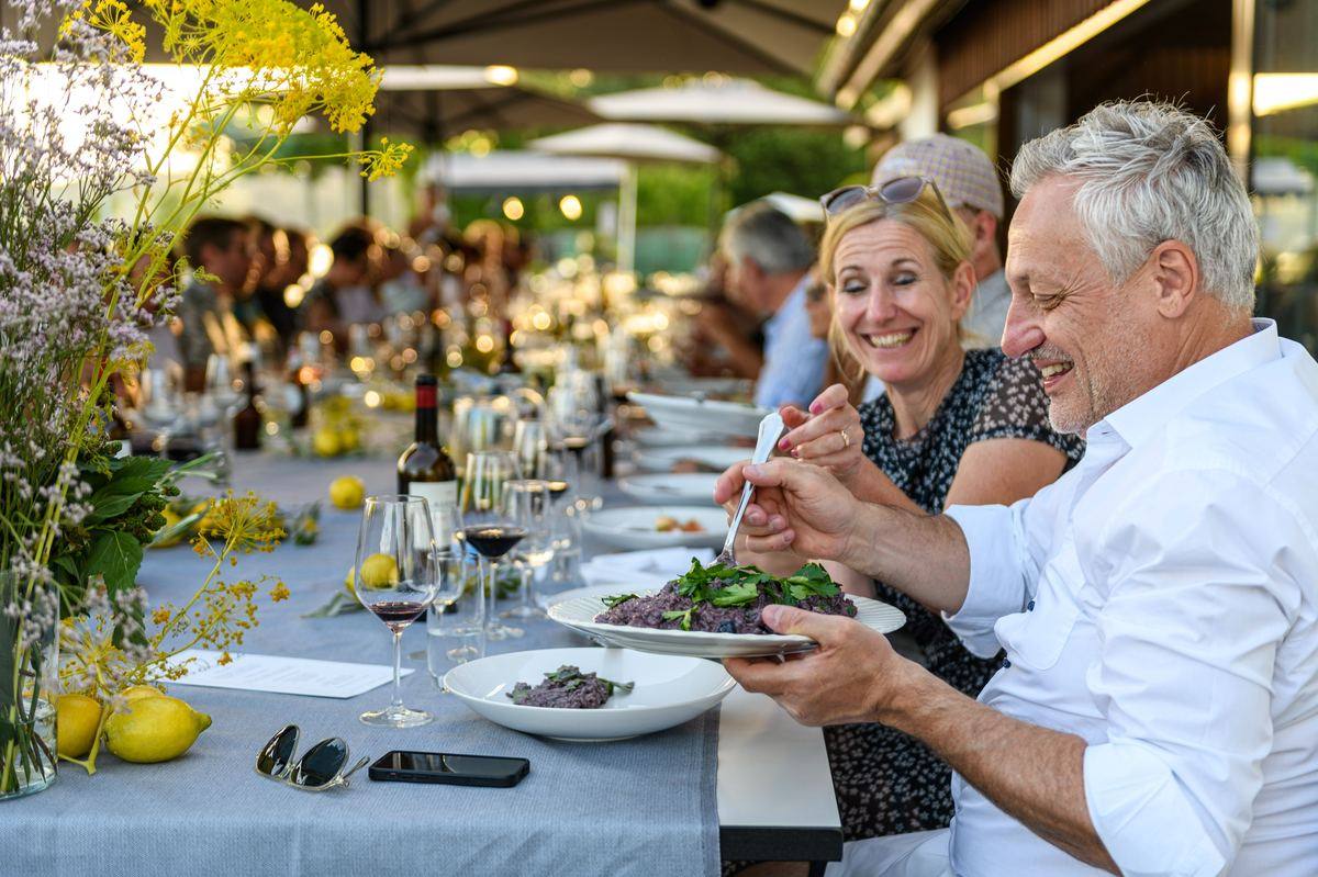 Guests at the long table at an outdoor summer party: event catering in Zürich
