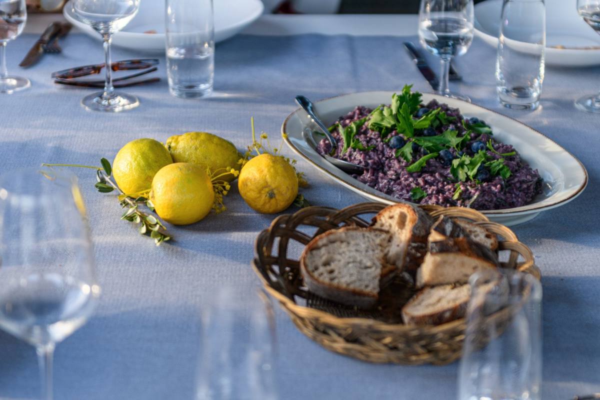 Tavolata mit Heidelbeer-Risotto, Zitronen und Brot in der Mitte des Tisches, Catering Zürich