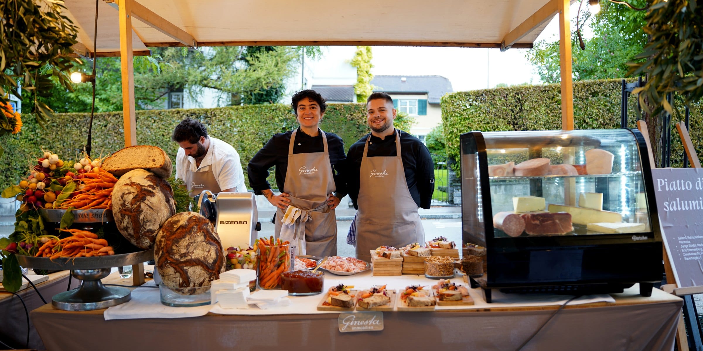 The michele kocht team behind the apéro stand with sourdough, vegetables and a meat slicer, Zürich catering