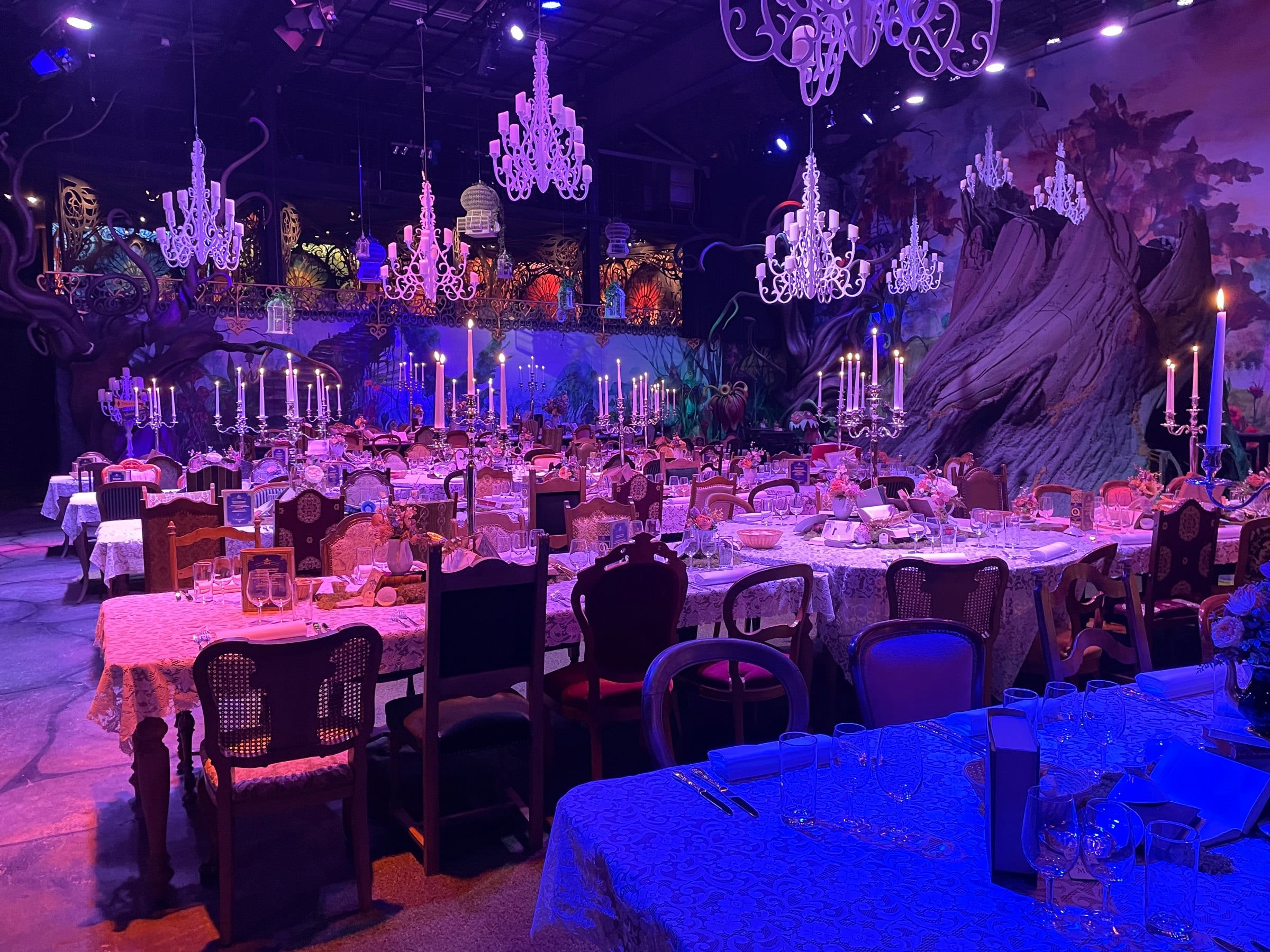 Festsaal im Astara in violettem Licht mit Kronleuchtern und gedeckten Tischen: Firmen-Weihnachtsfeier mit Catering aus Zürich